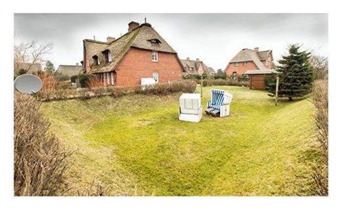 two chairs sitting in the grass in front of a house at Westhof-3 in List