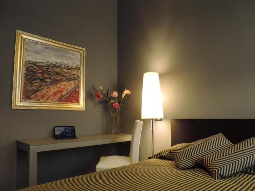 ピサにあるCorridoni Suitesのベッドルーム1室(ベッド1台、花瓶付きのテーブル付)