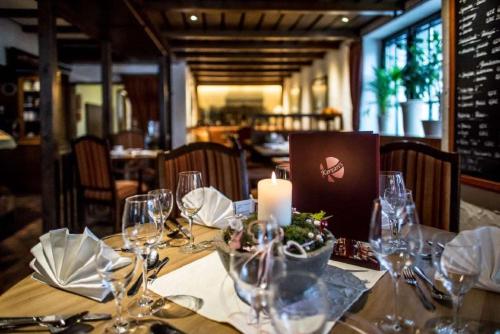 a table with wine glasses and a candle on it at Hotel- Restaurant Kerzan´s in Dortmund