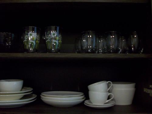a shelf with glasses and plates and cups on it at Kelluka Holiday House in Pärispea