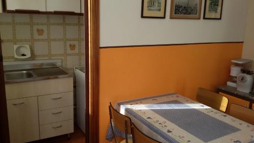 a small kitchen with a table and a sink at Casa Aralia con giardino in Chianciano Terme
