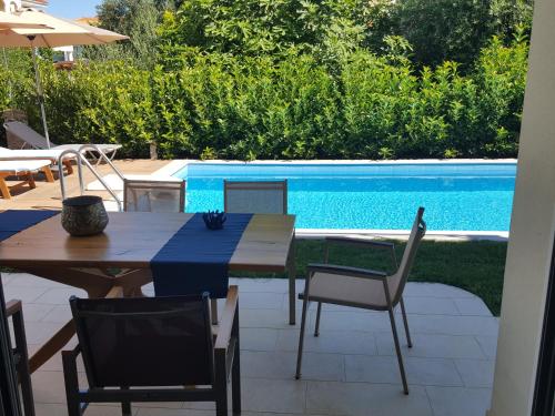a table and chairs next to a swimming pool at Ionian Green Villas in Preveza