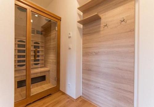 Una ducha a ras de suelo en una habitación con paredes de madera. en Apartmány Nová Pec, en Nová Pec