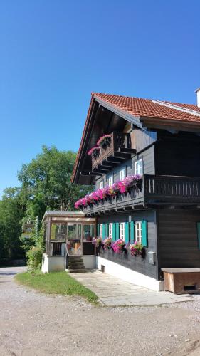 un edificio con flores y balcones. en Schatzbergalm Pension, en Dießen am Ammersee