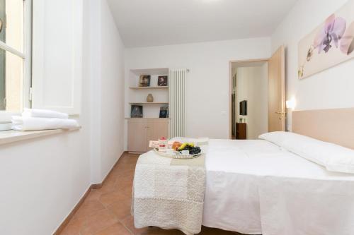 フィレンツェにあるWALKING 4の白いベッドルーム(ベッド1台付)、フルーツボウル1杯(テーブル上)