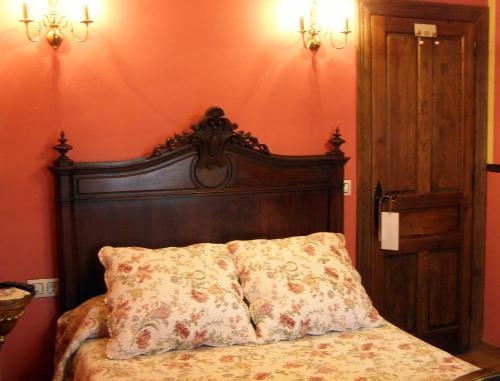 a bed with a wooden head board in a room at Posada Rural Ochohermanas in Las Fraguas