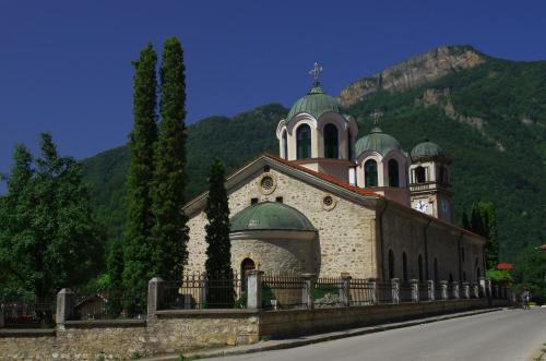 a building with a church on the side of a road at Семеен Хотел Вит in Teteven