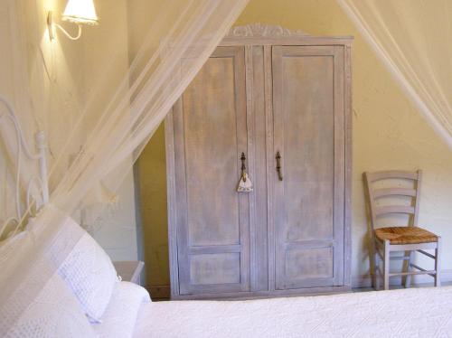 a bedroom with a wooden cabinet and a chair at Posada Rural Ochohermanas in Las Fraguas