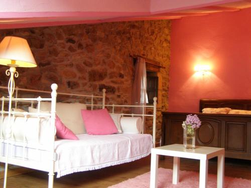 a living room with a white bed and a table at Posada Rural Ochohermanas in Las Fraguas