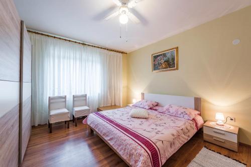sypialnia z łóżkiem i dwoma krzesłami w obiekcie Apartment Sandi w mieście Tinjan