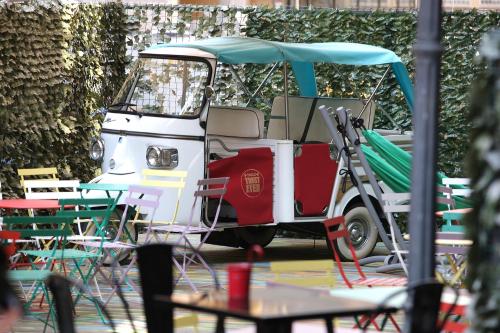 a golf cart parked next to tables and chairs at Hostel Trastevere in Rome