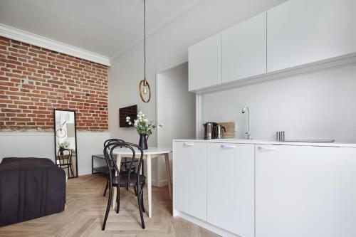 a kitchen and dining room with a brick wall at St Agnes Apartments Old Town in Kraków