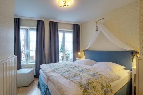 een slaapkamer met een groot bed met een blauw hoofdeinde bij Märchenhotel in Bernkastel-Kues