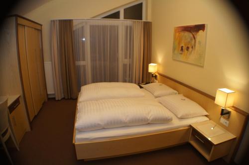 a bedroom with a bed with two white pillows at Hotel Sonneck in Schladming