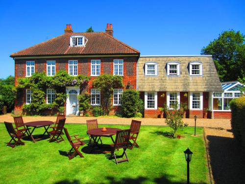 ein Haus mit einem Tisch und Stühlen im Hof in der Unterkunft Sherbourne House in Attleborough