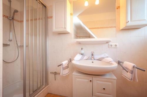 ein Bad mit einem Waschbecken und einer Dusche in der Unterkunft Haus Anke, Wohnung Muschelsucher, Westerlandstr. 37 in Wenningstedt-Braderup