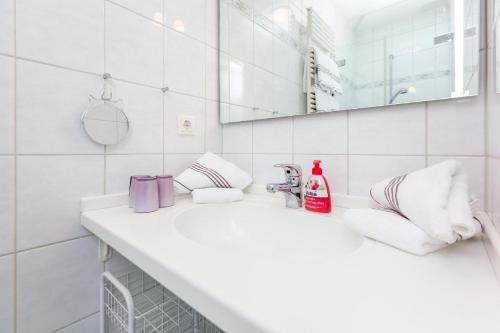 Baño blanco con lavabo y espejo en Ferienwohnung-Finlandia, en Westerland