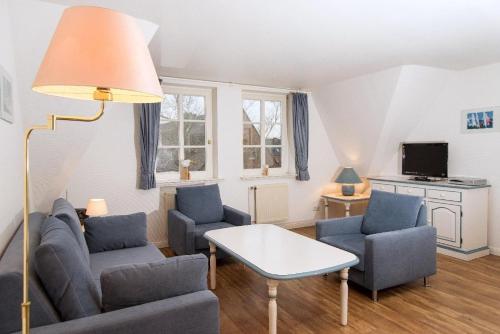 ein Wohnzimmer mit einem Sofa, Stühlen und einem Tisch in der Unterkunft Westhof 6 in List