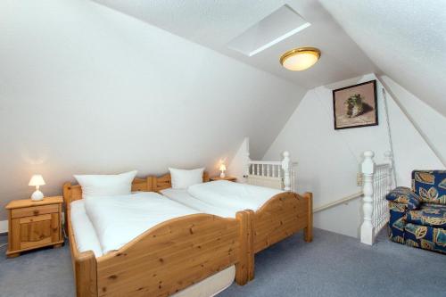 ein Schlafzimmer mit einem Holzbett im Dachgeschoss in der Unterkunft Westhof 6 in List