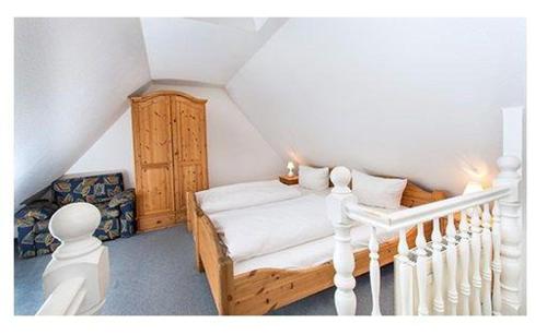 ein kleines Schlafzimmer mit einem Bett und einer Treppe in der Unterkunft Westhof 6 in List