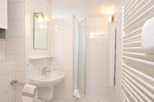 a white bathroom with a sink and a shower at Sylter-Mitte in Westerland (Sylt)