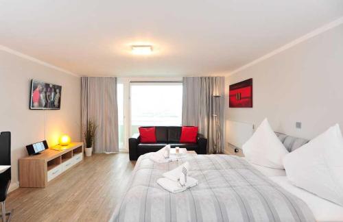 ヴェスターラントにあるSylter-Mitteの大きなベッドとソファが備わるホテルルームです。