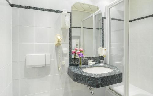 a bathroom with a sink and a mirror at PANORAMA Hotel Heimbuchenthal in Heimbuchenthal