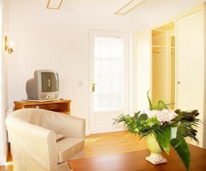 ein Wohnzimmer mit einem Sofa und einer Vase aus Blumen in der Unterkunft Sylter Besserburg App.4P in Westerland