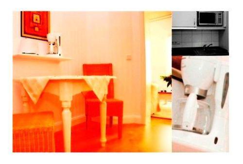 eine Küche mit einem Tisch und roten Stühlen sowie eine Küche mit einem Tisch in der Unterkunft Sylter Besserburg App.4P in Westerland