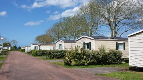 a row of mobile homes on a dirt road at Camping le Mont Joli Bois in Criel-sur-Mer