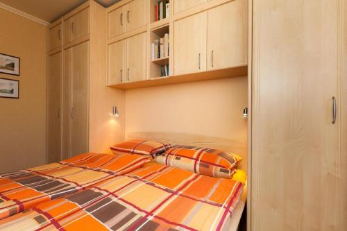 韋斯特蘭的住宿－Appartement-Makrele，一间带一张床和橱柜的小卧室