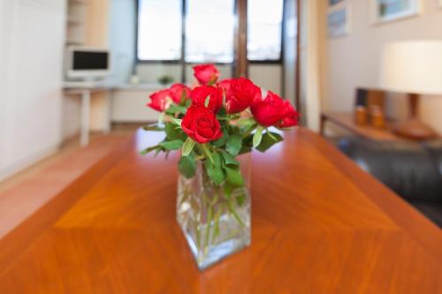 ヴェスターラントにあるAppartement-Makreleのテーブルに座る赤いバラの花瓶