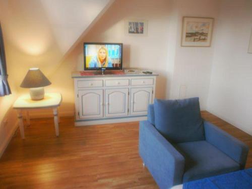 uma sala de estar com um sofá azul e uma televisão em Westhof-7 em List