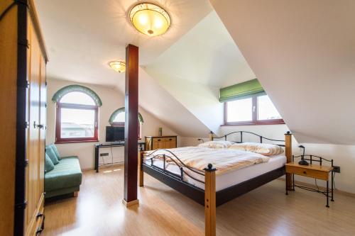 a attic bedroom with a bed and a couch at Farma Loreta in Vlašim