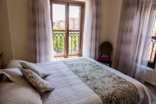 a bedroom with a large bed with a window at Asamina Boutique Hotel in Soûr