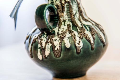 a green vase sitting on top of a table at Asamina Boutique Hotel in Soûr