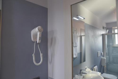a bathroom with a phone hanging on the wall at Best Western Plus Soave Hotel in San Bonifacio