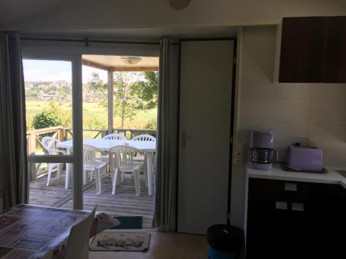 a kitchen with a balcony with a table and chairs at Camping le Mont Joli Bois in Criel-sur-Mer