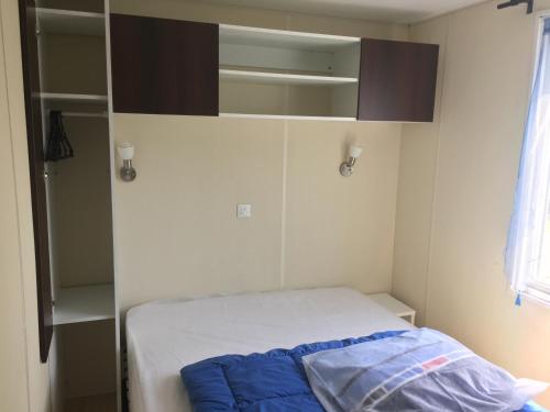 - une petite chambre avec un lit et un placard dans l'établissement Camping le Mont Joli Bois, à Criel-sur-Mer