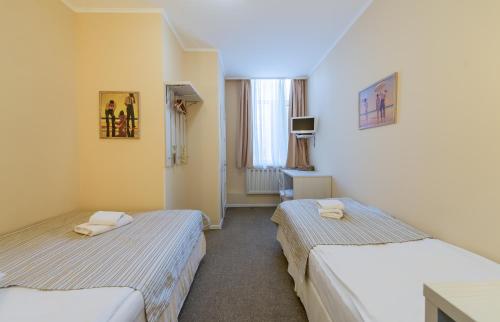 a room with two beds and a window at light hotel & hub in Kyiv