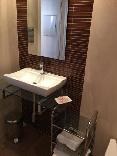 een badkamer met een wastafel en een spiegel bij Boulevard Suite Cordoba in Córdoba