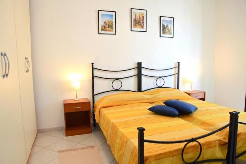 sypialnia z łóżkiem z niebieskimi poduszkami w obiekcie Casa Rosada Alghero w mieście Alghero