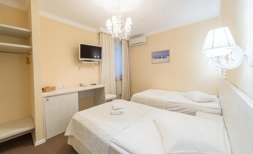 a hotel room with two beds and a chandelier at light hotel & hub in Kyiv