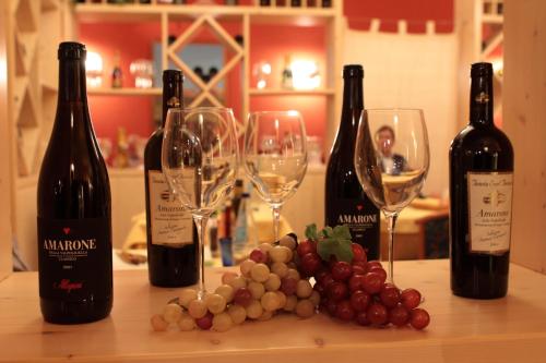 three bottles of wine and wine glasses on a table at Best Western Plus Soave Hotel in San Bonifacio