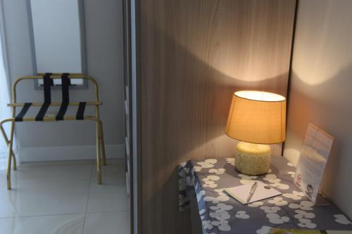 a lamp on a table in a room with a chair at CASA FELICE Suite Room in Taranto