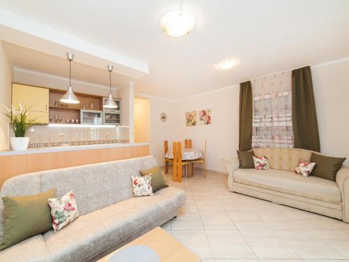 a living room with two couches and a kitchen at Apartments Spin in Budva