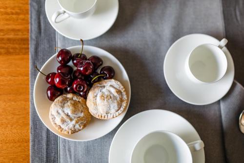 a table with plates of muffins and cups of coffee at Santa Maria Vecchia Relais in Vico Equense