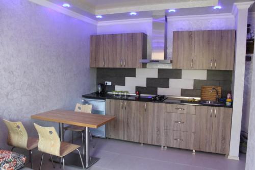a kitchen with wooden cabinets and a wooden table at OldBatumi Apartment in Batumi