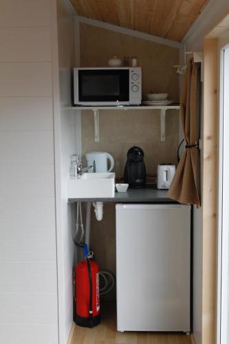 a small kitchen with a microwave and a red suitcase at The Castle in Búðardalur