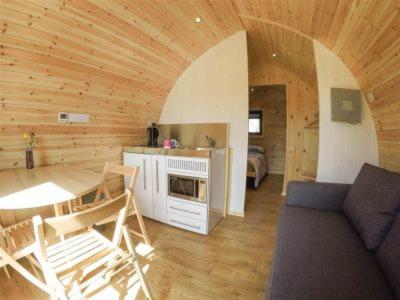 a living room with a couch and a table in a cabin at Cosy Camping Suffolk in Ipswich